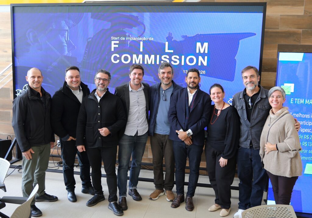 pessoas reunidas na frente de um painel azul escrito "Film Commission"
